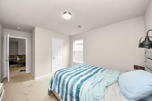 bedroom with baseboards, visible vents, and light colored carpet