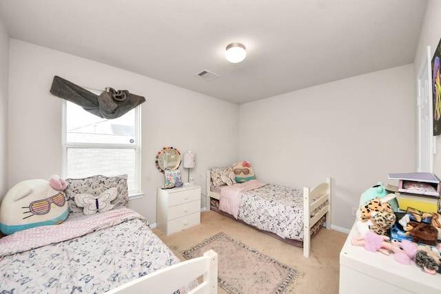 bedroom featuring baseboards, visible vents, and light colored carpet