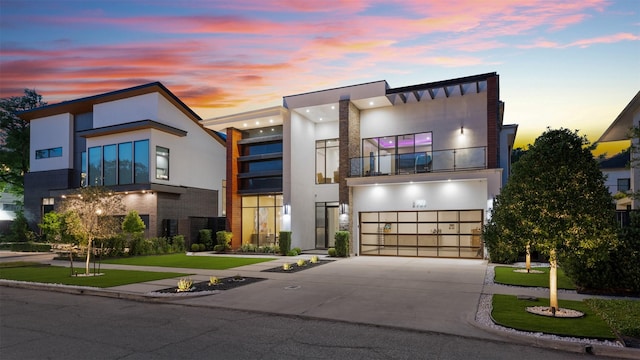 2703 Westgrove Ln, Houston, TX 77027 - modern home featuring stucco siding, an attached garage, driveway, and a balcony