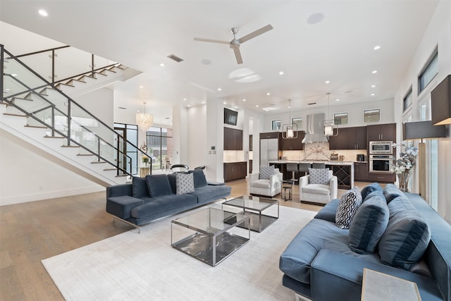 2703 Westgrove Ln, Houston, TX 77027 - living area with stairway, ceiling fan with notable chandelier, light wood finished floors, visible vents, and recessed lighting