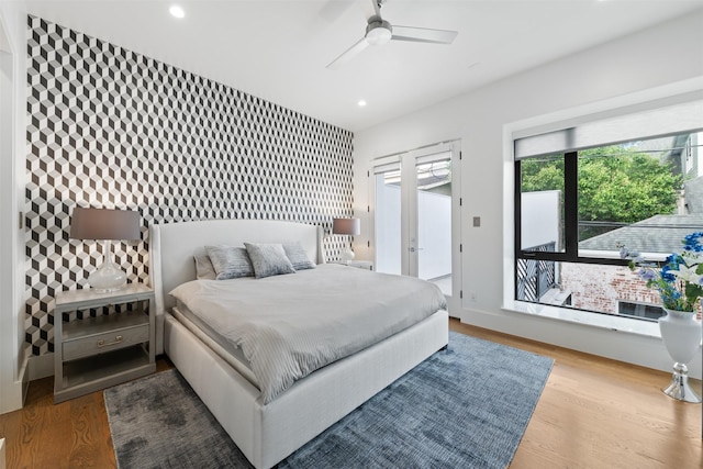 2703 Westgrove Ln, Houston, TX 77027 - bedroom with access to exterior, an accent wall, recessed lighting, wallpapered walls, and wood finished floors