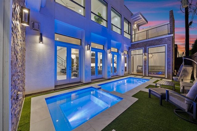 2703 Westgrove Ln, Houston, TX 77027 - pool at dusk with an outdoor pool, french doors, and an in ground hot tub
