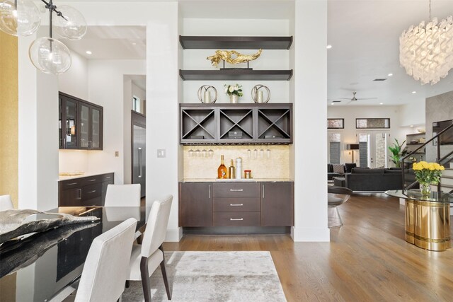 2703 Westgrove Ln, Houston, TX 77027 - bar featuring recessed lighting, wood finished floors, a dry bar, decorative light fixtures, and decorative backsplash