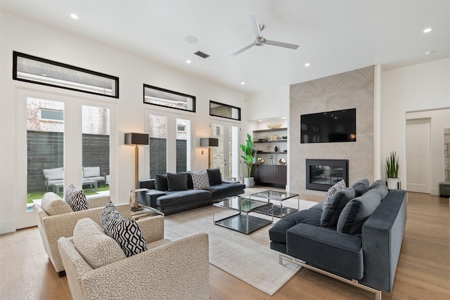2703 Westgrove Ln, Houston, TX 77027 - living room with a ceiling fan, recessed lighting, a tile fireplace, and light wood-style flooring