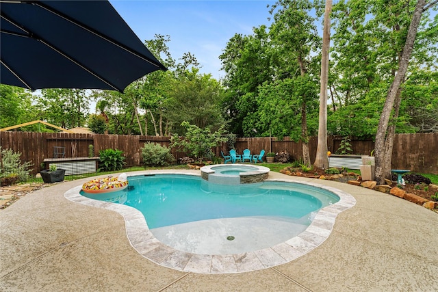 view of swimming pool featuring a pool with connected hot tub, a patio area, and a fenced backyard