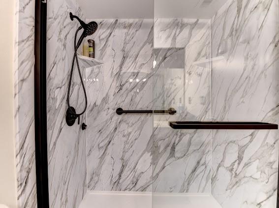 bathroom with a marble finish shower