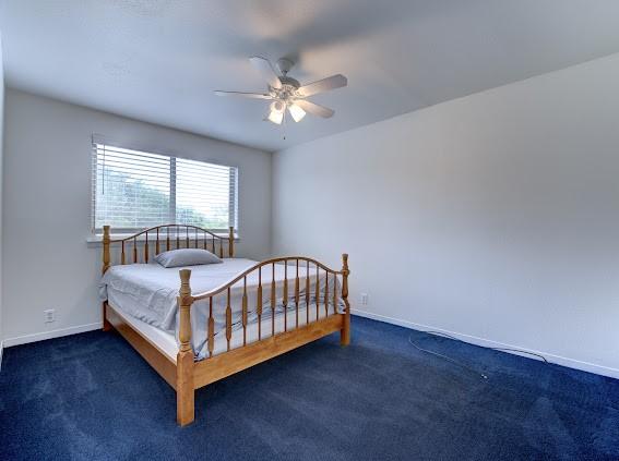 carpeted bedroom with baseboards and a ceiling fan