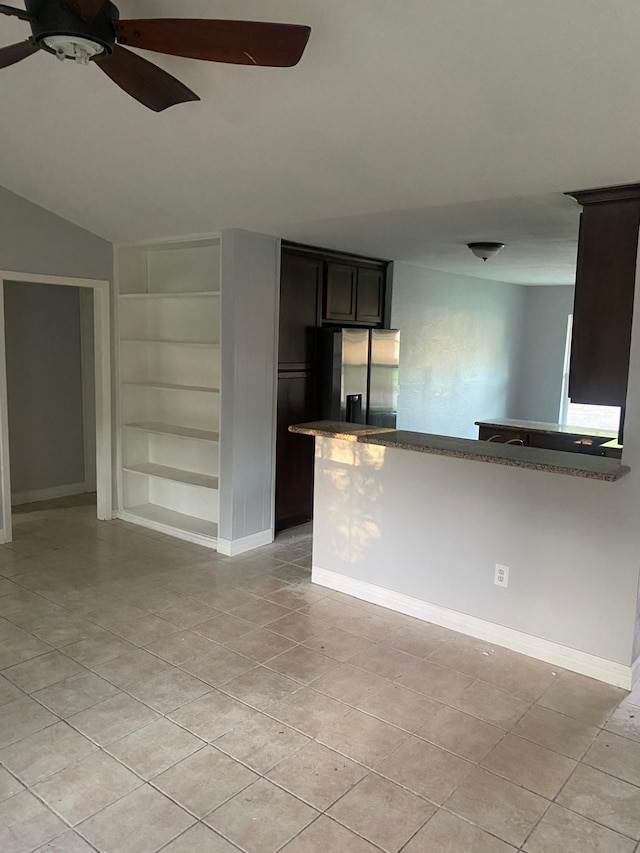 14418 Alkay St, Houston, TX 77045 - kitchen with light tile patterned floors, built in shelves, baseboards, stainless steel refrigerator with ice dispenser, and a ceiling fan