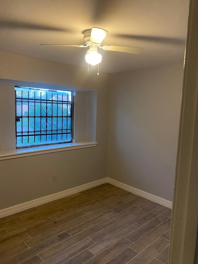 14418 Alkay St, Houston, TX 77045 - unfurnished room with ceiling fan, baseboards, and dark wood finished floors