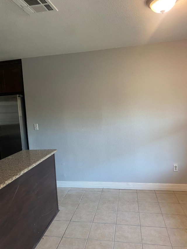 14418 Alkay St, Houston, TX 77045 - unfurnished dining area with light tile patterned flooring, visible vents, and baseboards