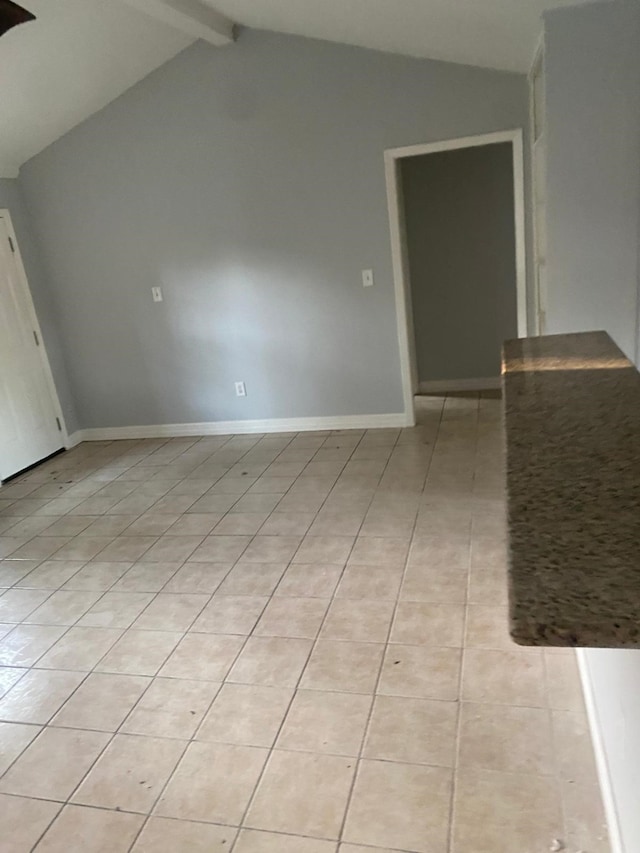 14418 Alkay St, Houston, TX 77045 - empty room featuring lofted ceiling with beams, light tile patterned floors, and baseboards