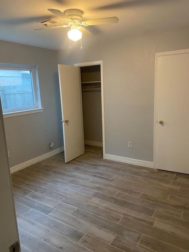 14418 Alkay St, Houston, TX 77045 - unfurnished bedroom featuring visible vents, ceiling fan, a closet, baseboards, and wood finished floors