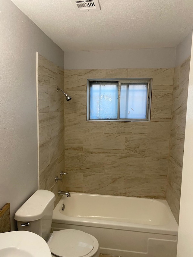 14418 Alkay St, Houston, TX 77045 - bathroom featuring shower / bathing tub combination, a textured ceiling, visible vents, and toilet