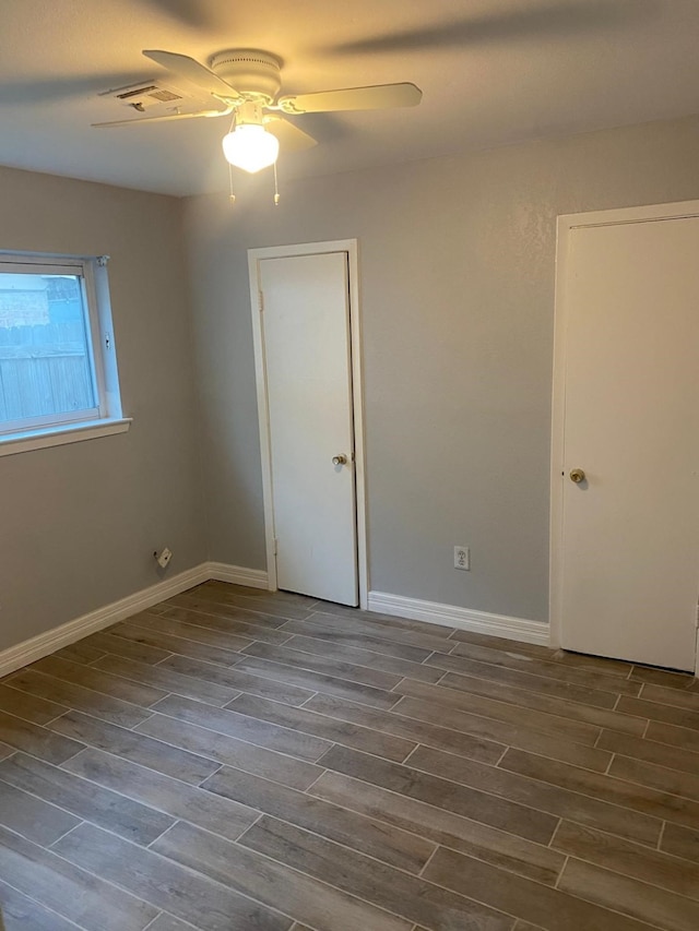 14418 Alkay St, Houston, TX 77045 - spare room featuring wood finished floors, a ceiling fan, and baseboards