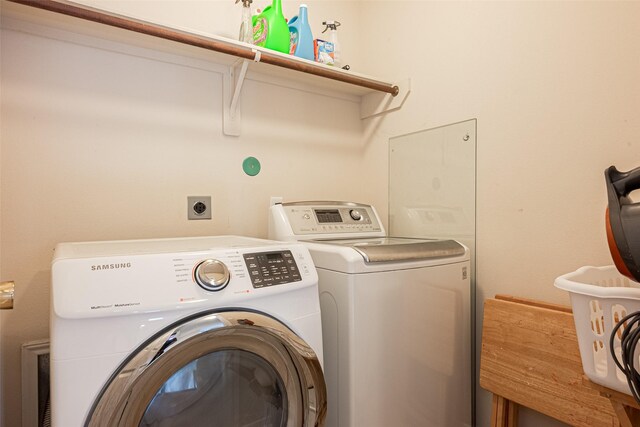 washroom with washing machine and dryer and laundry area