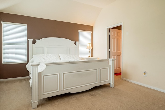 bedroom with lofted ceiling, baseboards, and light colored carpet