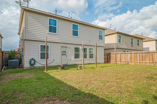 rear view of house featuring a yard and a fenced backyard