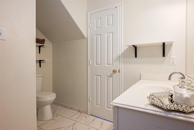 bathroom with marble finish floor, toilet, and vanity
