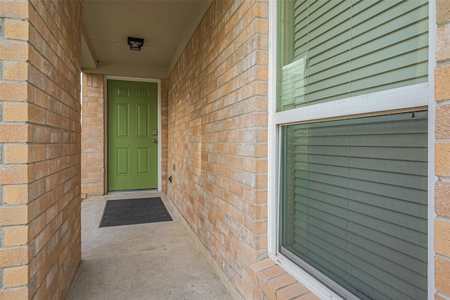 view of exterior entry with brick siding