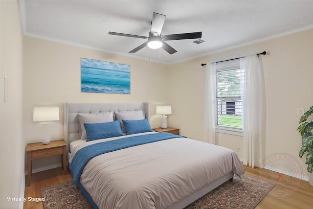 bedroom with ornamental molding, wood finished floors, baseboards, and ceiling fan