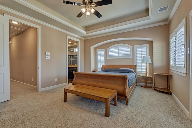 bedroom featuring ornamental molding, light carpet, visible vents, and a raised ceiling