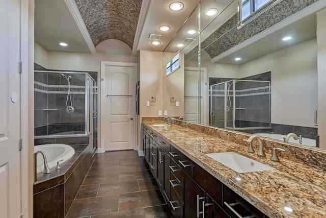 bathroom with a shower stall, double vanity, a sink, crown molding, and a garden tub