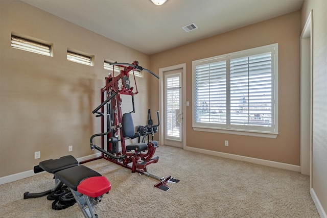 exercise room featuring visible vents, carpet flooring, and baseboards