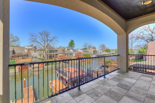 balcony with a residential view and a water view