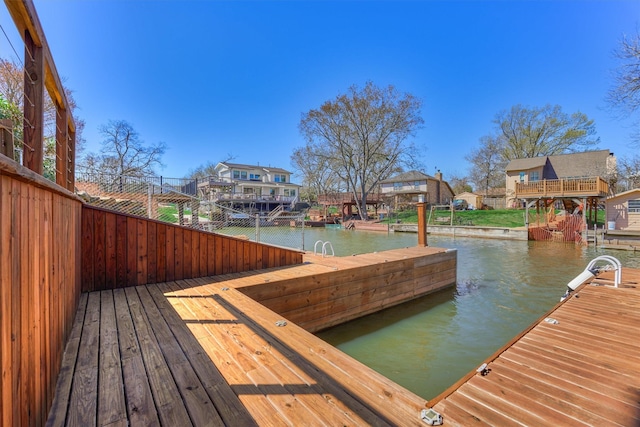 view of dock with a residential view and a water view