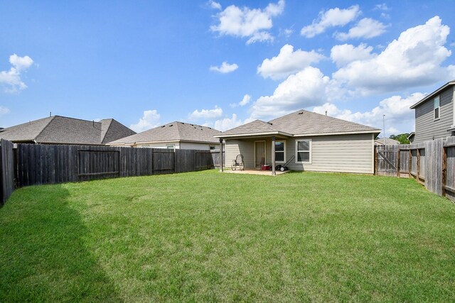 rear view of house with a patio area, a lawn, and a fenced backyard
