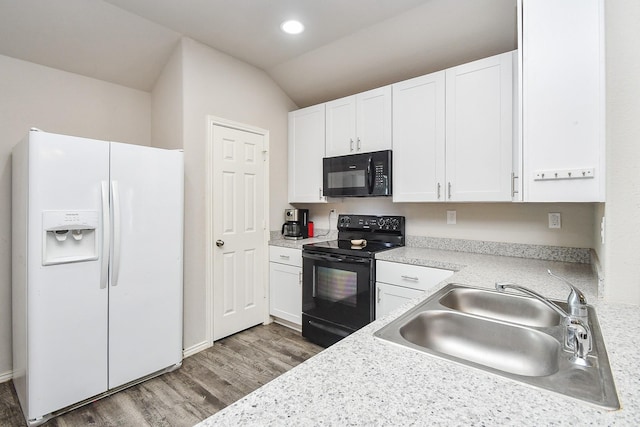 kitchen with black appliances, white cabinetry, wood finished floors, and a sink