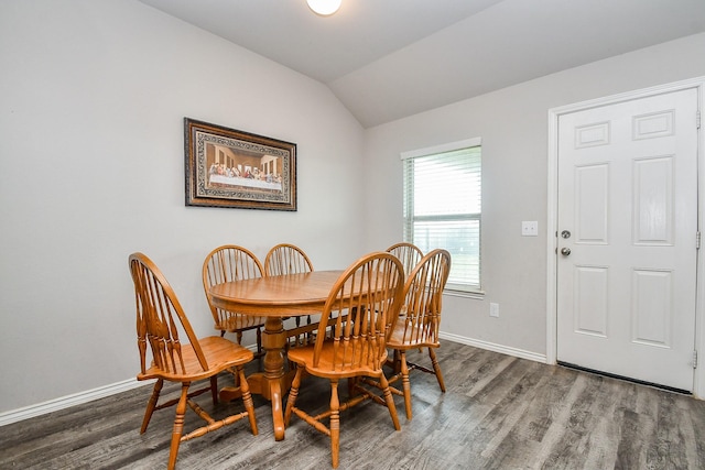 dining space with vaulted ceiling, wood finished floors, and baseboards