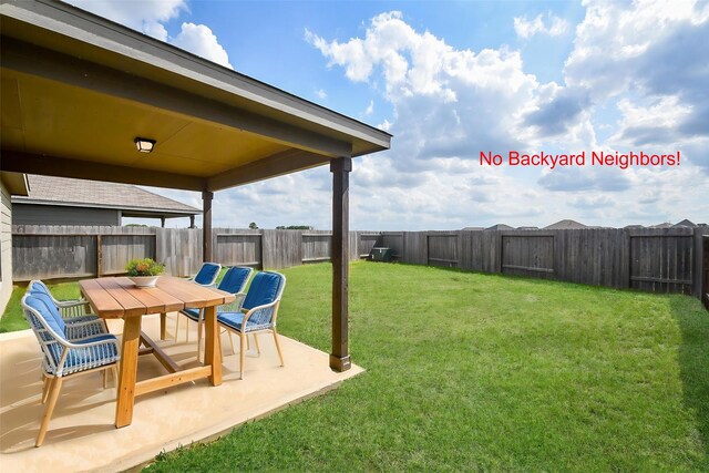 view of yard featuring a fenced backyard, outdoor dining space, and a patio