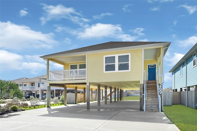 269 Bay Oaks Dr, La Porte, TX 77571 - raised beach house with driveway, a carport, stairway, and fence