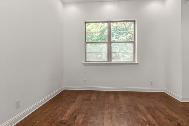 611 Mazal Ln, Houston, TX 77009 - spare room featuring baseboards and dark wood-style flooring
