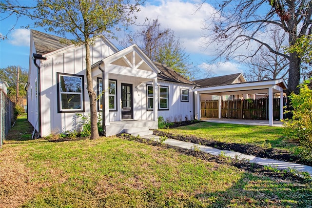 4716 Siegel St, Houston, TX 77009 - view of front of property with a front lawn, board and batten siding, a detached carport, and fence