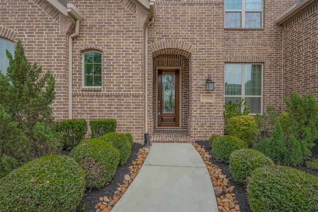 entrance to property featuring brick siding