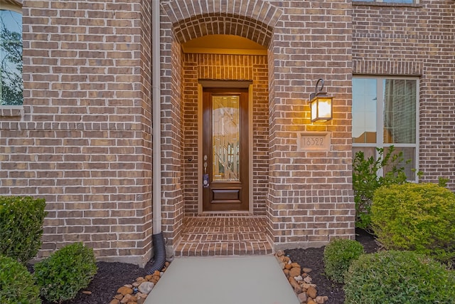 view of exterior entry with brick siding