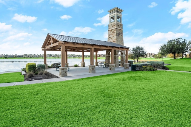view of property's community with a gazebo, a water view, and a lawn