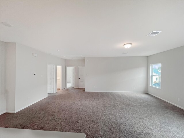carpeted spare room with baseboards and visible vents