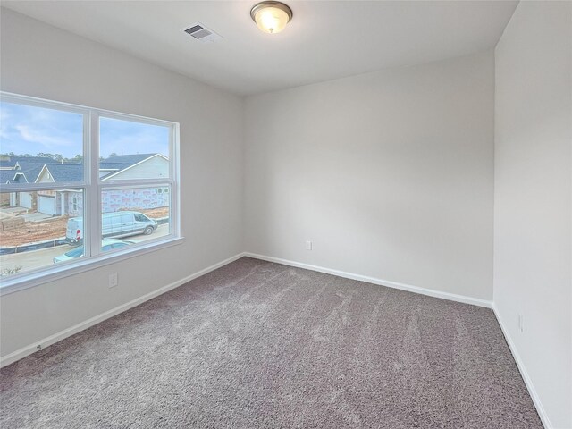 unfurnished room with visible vents, carpet flooring, and baseboards