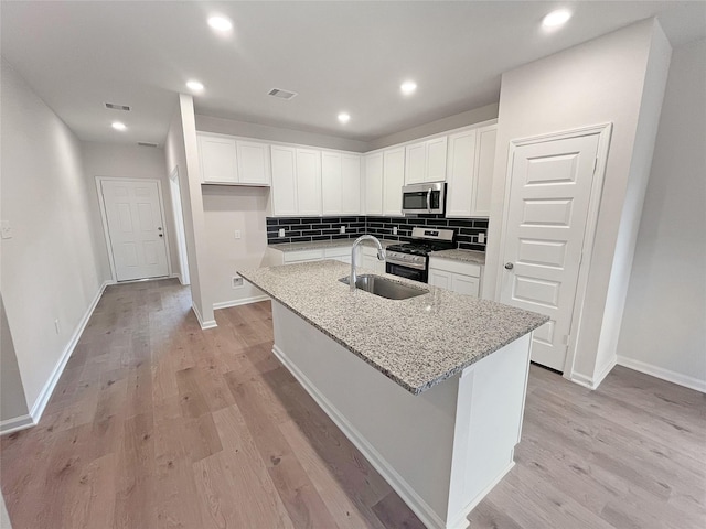 kitchen with light wood-type flooring, visible vents, a sink, and appliances with stainless steel finishes