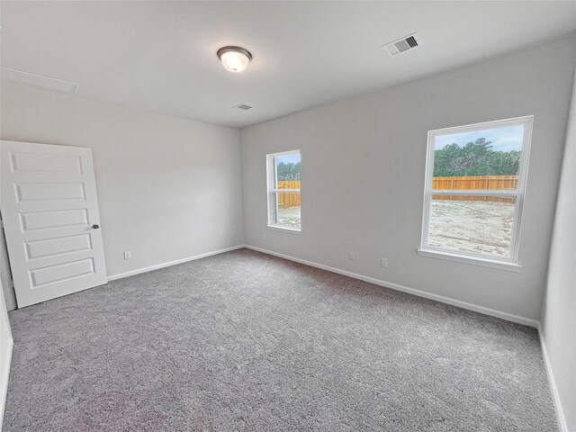 spare room with baseboards, visible vents, and carpet
