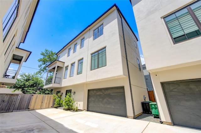 1509 Caywood Ln Unit C, Houston, TX 77055 - view of front of house featuring an attached garage, stucco siding, driveway, fence, and a balcony