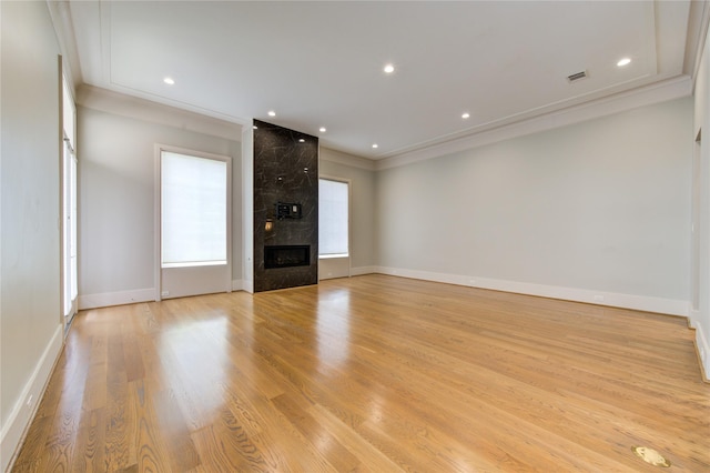 1509 Caywood Ln Unit C, Houston, TX 77055 - unfurnished living room featuring light wood-style flooring, a large fireplace, crown molding, baseboards, and recessed lighting