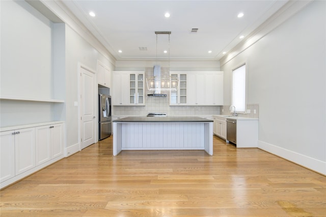 1509 Caywood Ln Unit C, Houston, TX 77055 - kitchen featuring stainless steel appliances, ventilation hood, a kitchen island, white cabinets, and glass insert cabinets