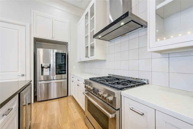 1509 Caywood Ln Unit C, Houston, TX 77055 - kitchen featuring appliances with stainless steel finishes, wall chimney exhaust hood, beverage cooler, and white cabinets