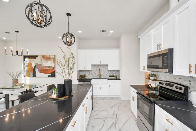 kitchen featuring dark countertops, appliances with stainless steel finishes, marble finish floor, and recessed lighting