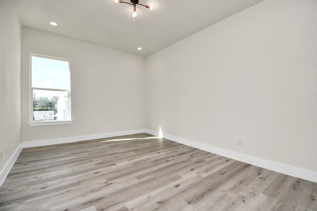 empty room featuring recessed lighting, wood finished floors, and baseboards