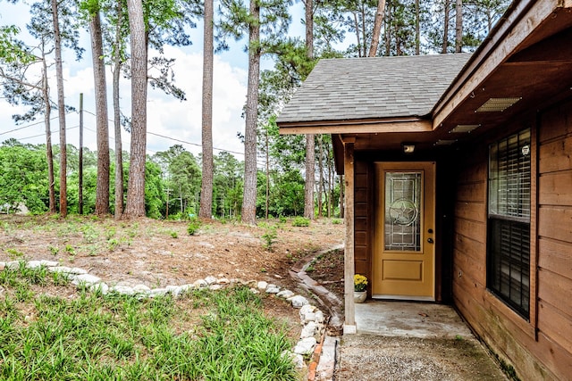 property entrance with a shingled roof